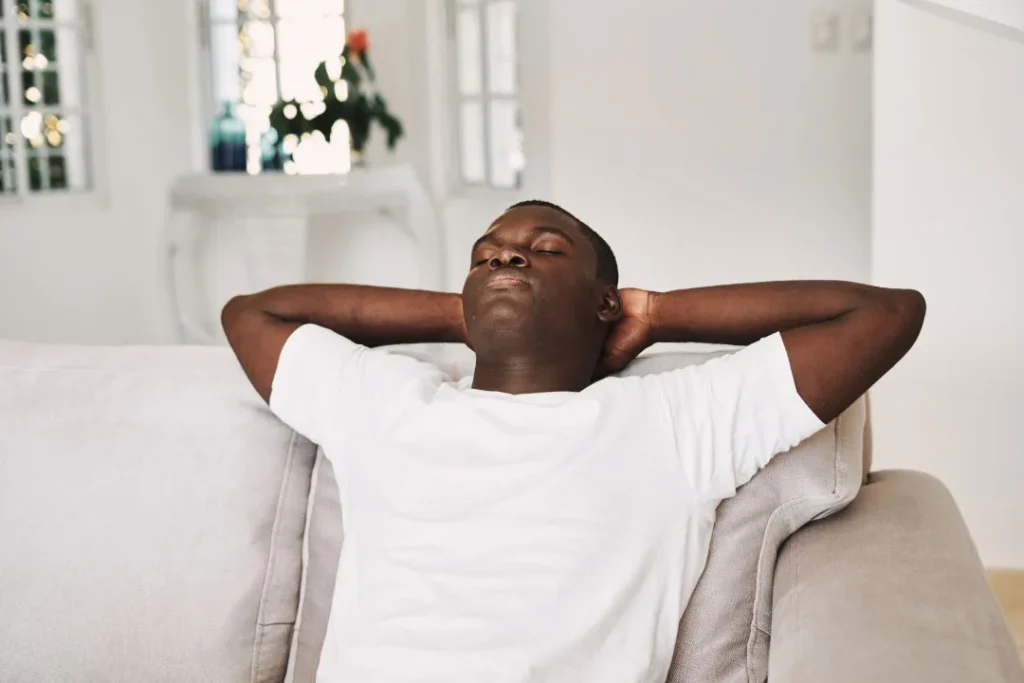 A black man taking rest while sitting on the couch. 